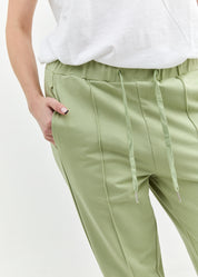 Pants with a seam in the middle and a smoky light green patch