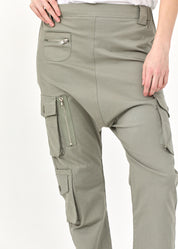 Длинные брюки с зелеными карманами-карго.