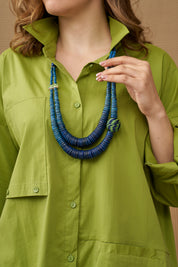 A necklace of coconut discs and a blue coiled bead