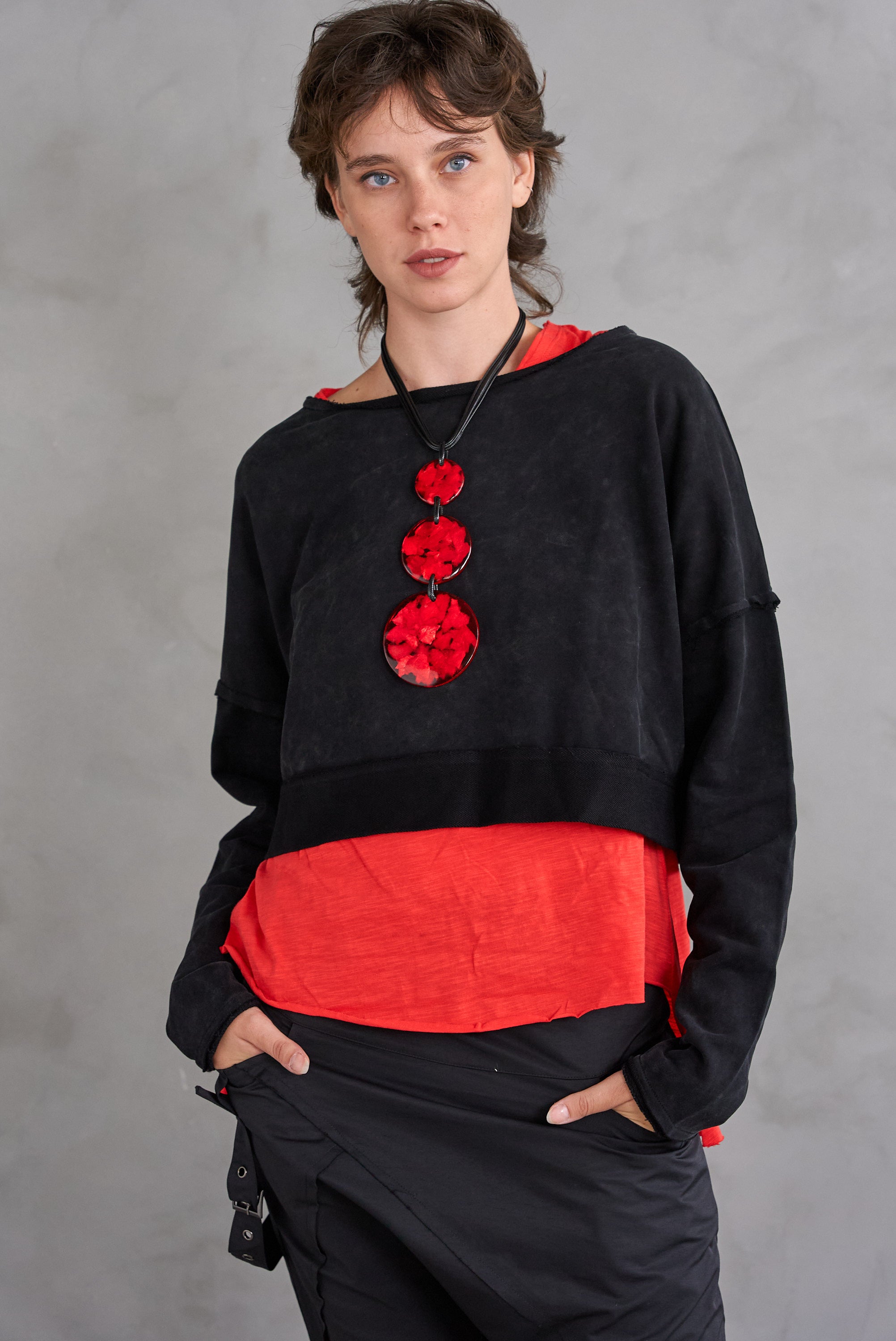 A chain of 3 resin circles on a red thread