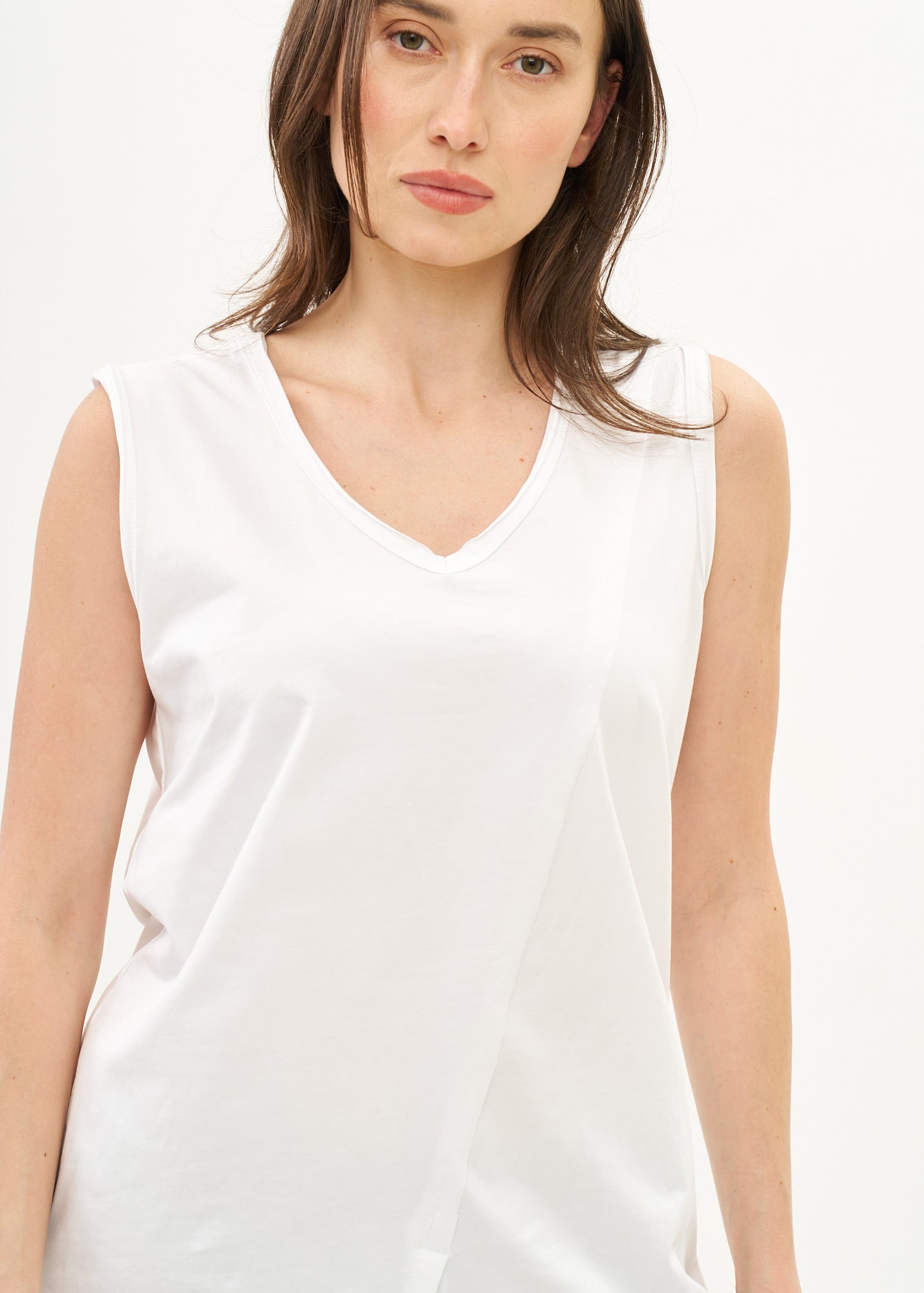 White V-neck tank top with diagonal stitching and slits